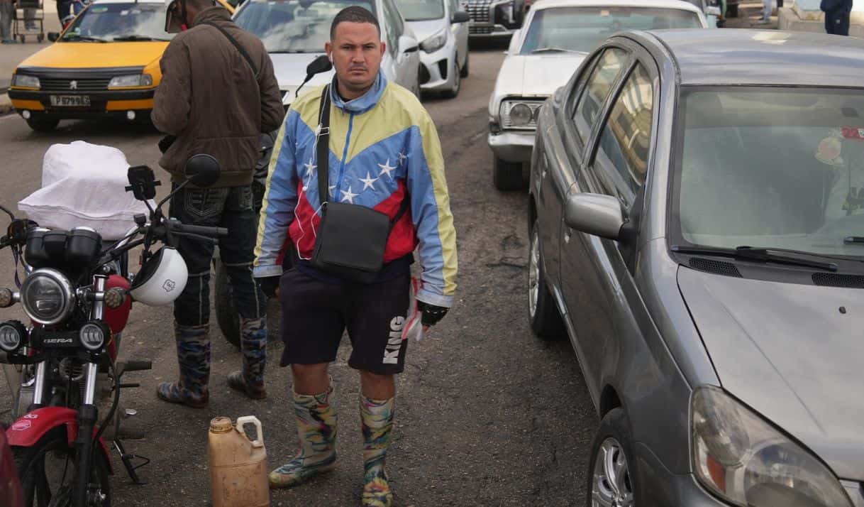 Un hombre con una chaqueta con los colores de la bandera de Venezuela hace fila para comprar combustible en una gasolinera, el viernes 6 de febrero de 2026, en La Habana, Cuba. (AP Foto/Ramón Espinosa)